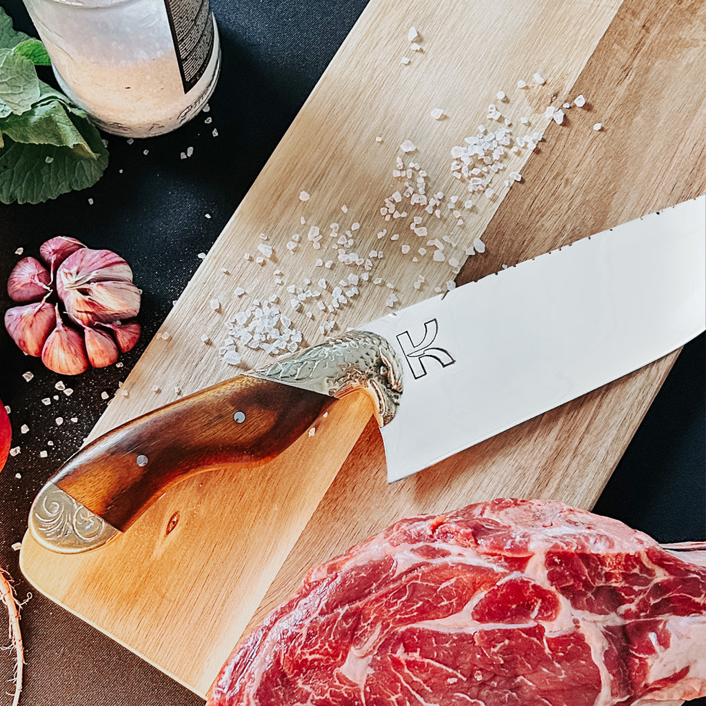 Faca picanheira chef 8 polegadas, sendo mostrada encima de uma tábua de carne para churrasco, exibindo seus detalhes